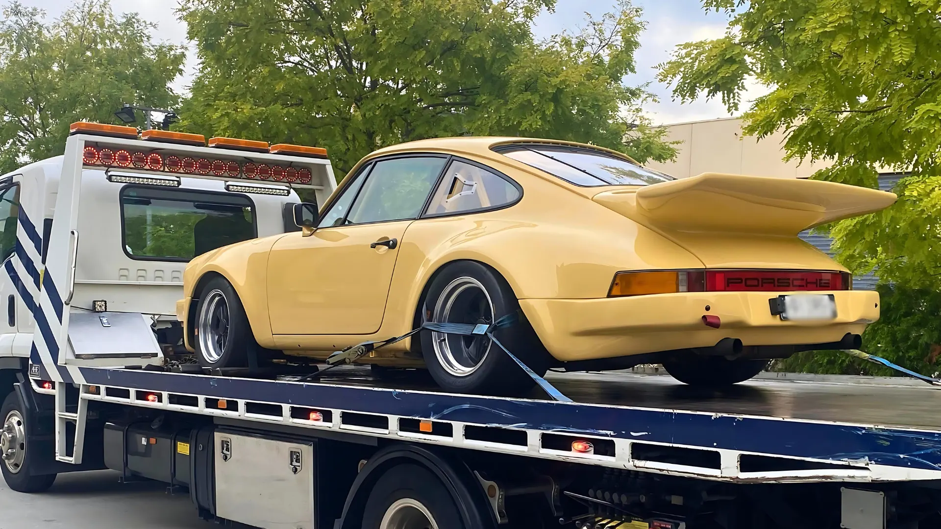 Classic yellow Porsche 911 secured on the All Over Towing tilt tray in Melbourne